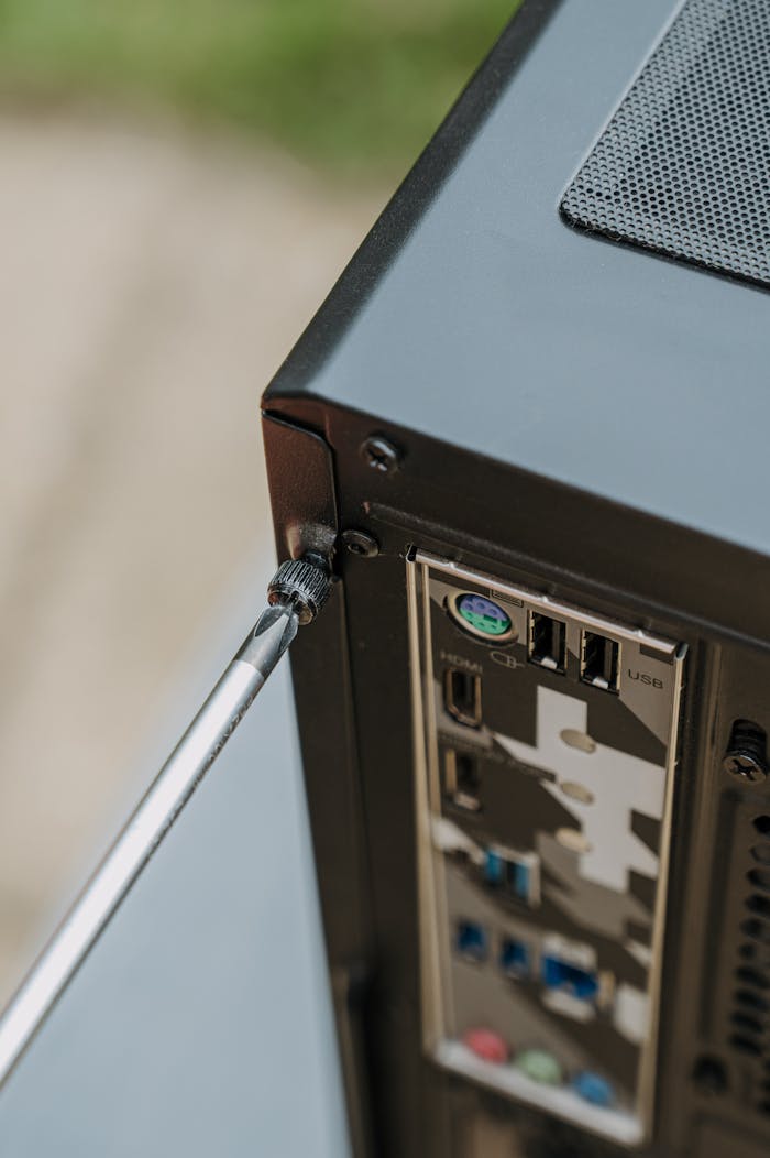 Close-up of unscrewing a PCs back panel for DIY maintenance.